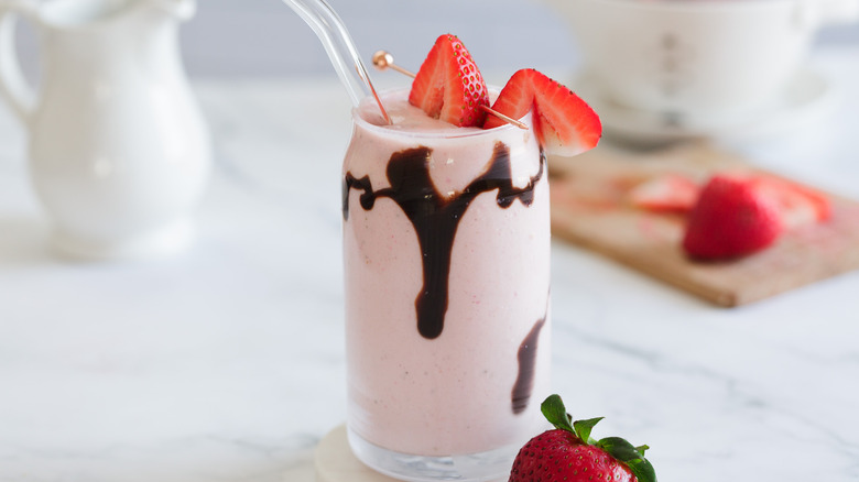 milkshake with straw and milk carafe in background