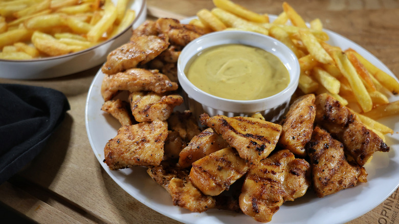 plate of copycat chick-fil-a grilled nuggets and french fries with copycat chick-fil-a sauce