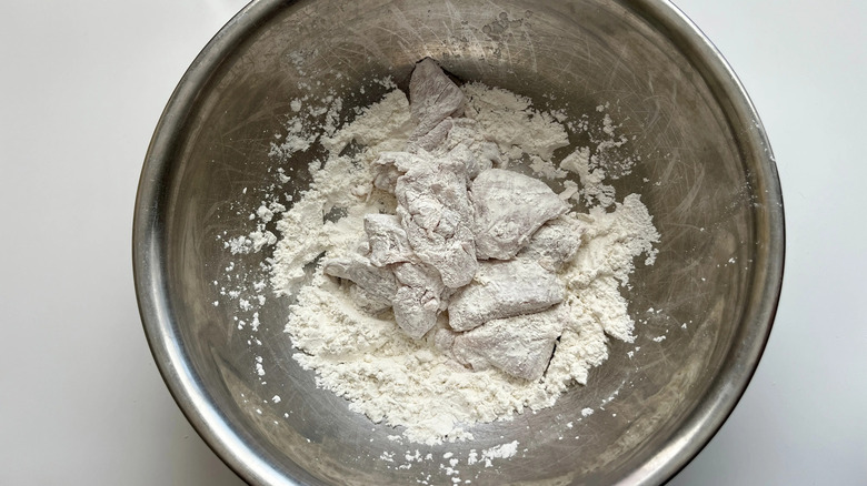 Chicken coated in flour in bowl