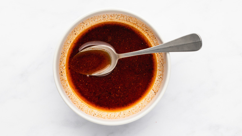 Oil and spice mixture in bowl with spoon