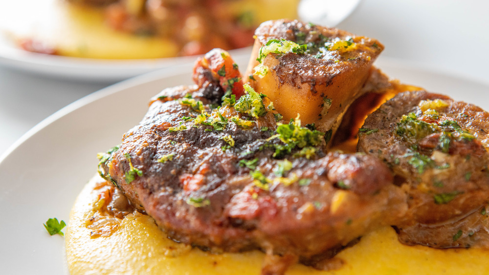 Finished ossobuco veal on white plate with polenta