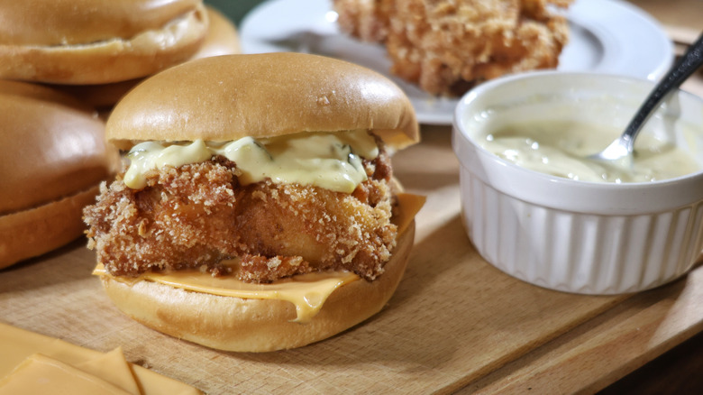 copycat filet-o-fish sandwich on cutting board with ramekin of tartar sauce